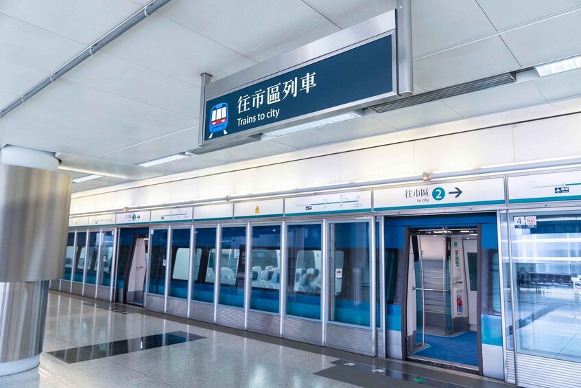 A modern train station with a sign indicating 'Trains to city' and a platform with a train door. 2