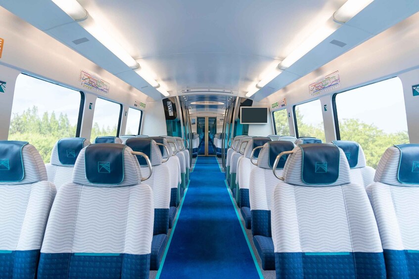 A train interior with rows of seats, overhead luggage racks, and windows. 5