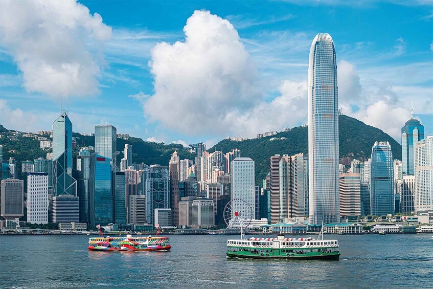A city skyline with modern skyscrapers and a green ferry in the water. 5