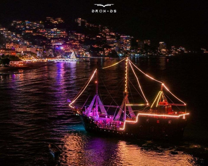 A brightly lit ship with a triangular structure, docked at night with a cityscape in the background. 4