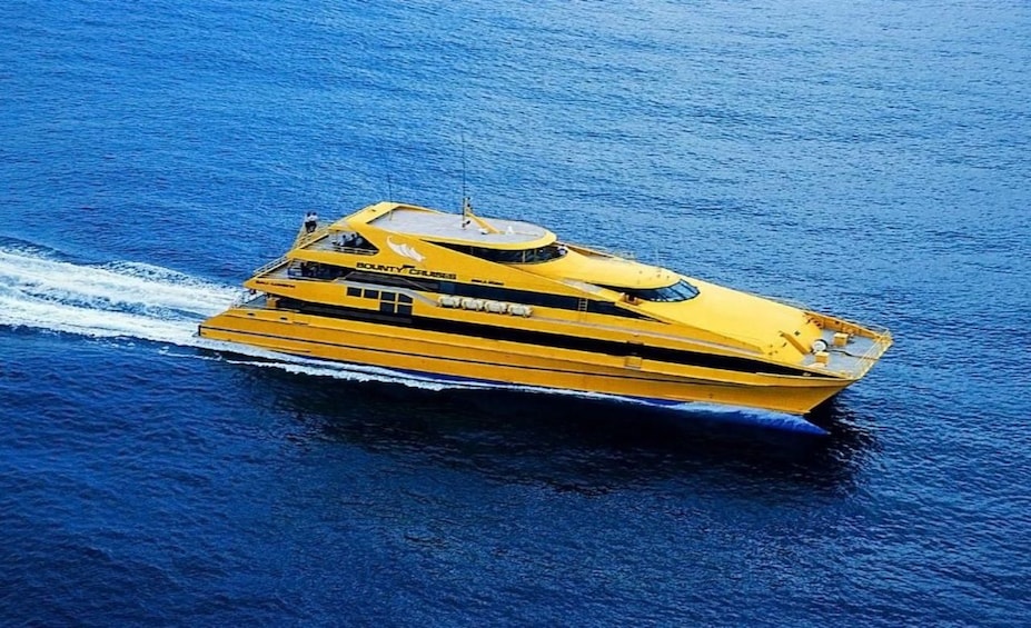 A yellow yacht with a cabin and a wake behind it. 1