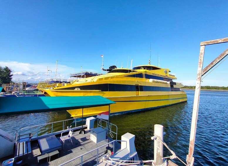 A large yellow yacht docked at a marina with clear skies. 5