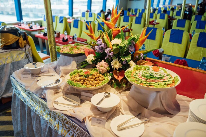 A buffet table with various dishes, including a baby potato salad, a cocktail sauce, and a salad with cucumbers and radishes. 2