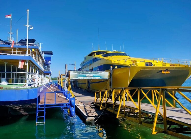 A dock with two yellow boats moored alongside a blue boat. 4