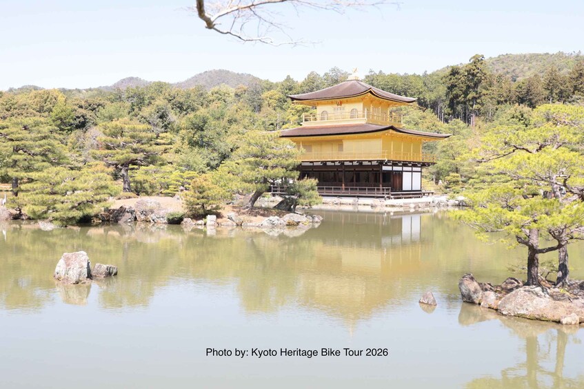 A traditional Japanese building by a calm pond surrounded by trees. 1