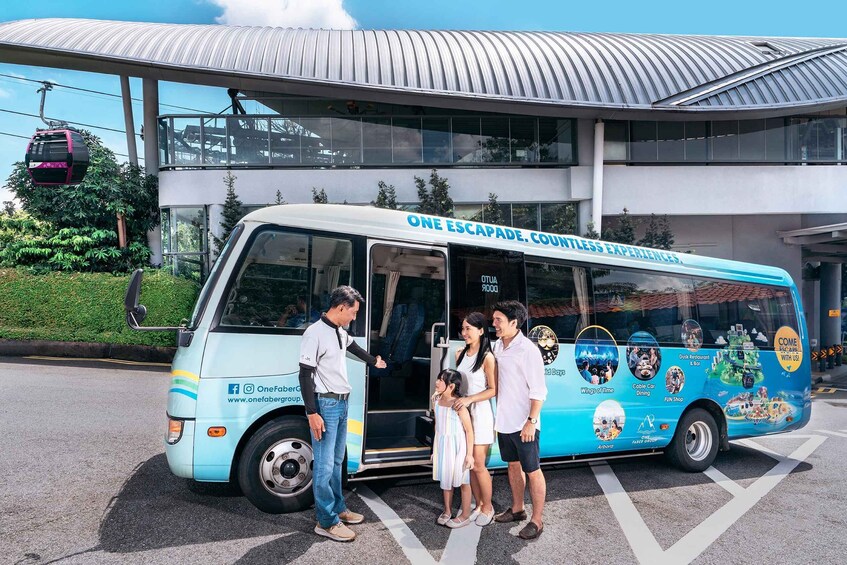 A blue bus with 'ONE ESCAPADE. CONTINENTLESS EXPERIENCES' written on the side, parked in front of a building with a curved roof. 3