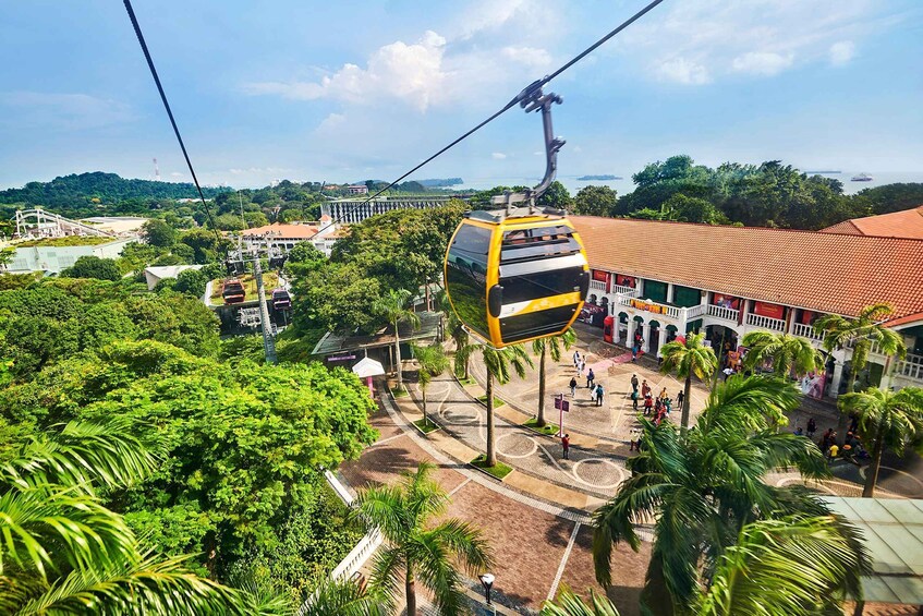 A cable car system with a yellow and black gondola, a traditional building with a red-tiled roof, and lush green trees. 5