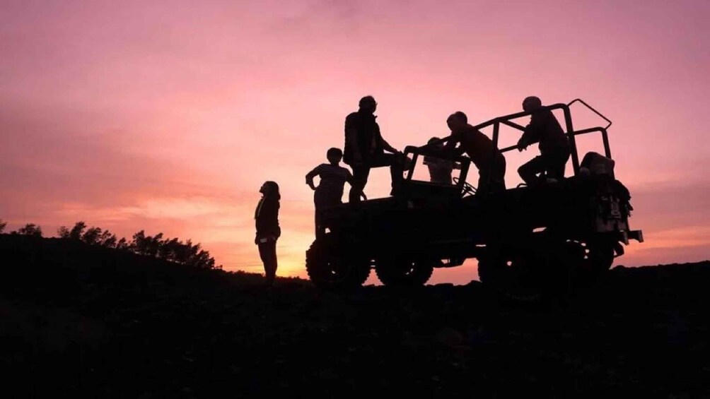 A group of people on a vehicle at sunset. 4