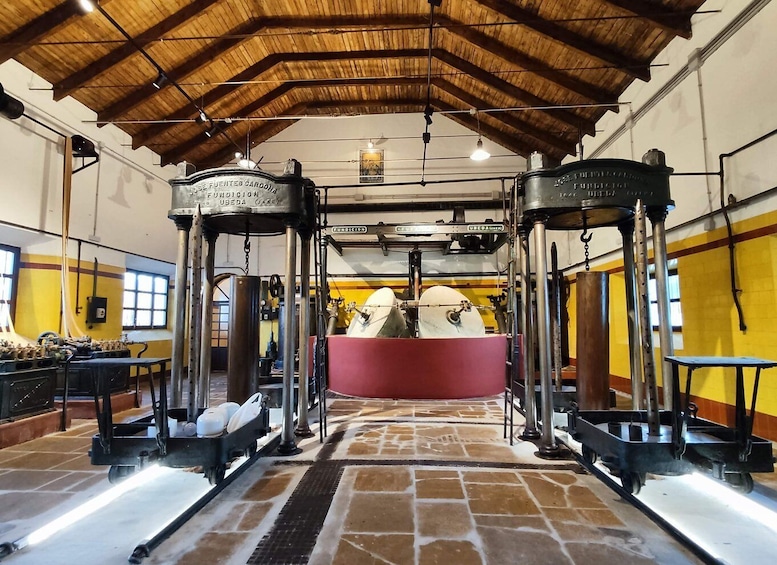 A vintage industrial setting with machinery, a central pink boiler, and wooden beams on the ceiling. 3