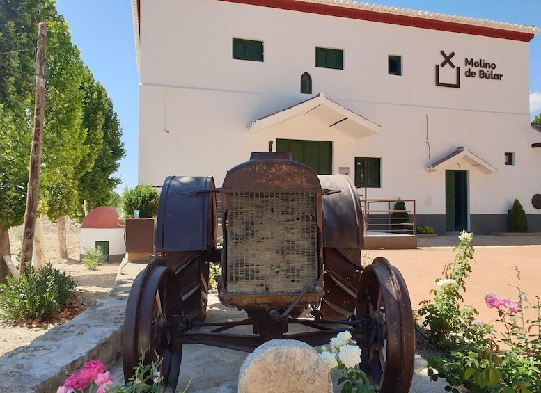 A vintage car with a large grille in front of a building labeled 'Molino de Bújar.' 2