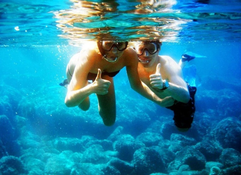 Two people underwater giving thumbs up. 2
