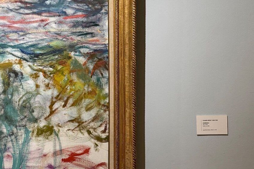 Un tableau encadré d’un cadre doré, avec une étiquette blanche, et accroché sur un mur uni. 4