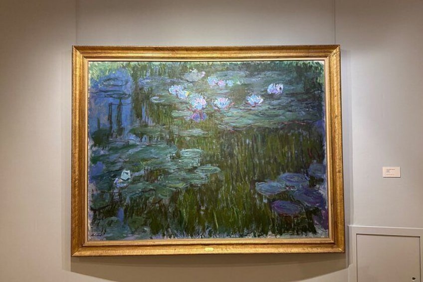 Un tableau encadré représentant des nénuphars, accroché à un mur. 5