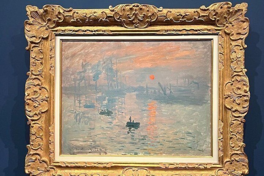 Un tableau encadré représentant une scène de rivière avec des bateaux et un coucher de soleil. 1