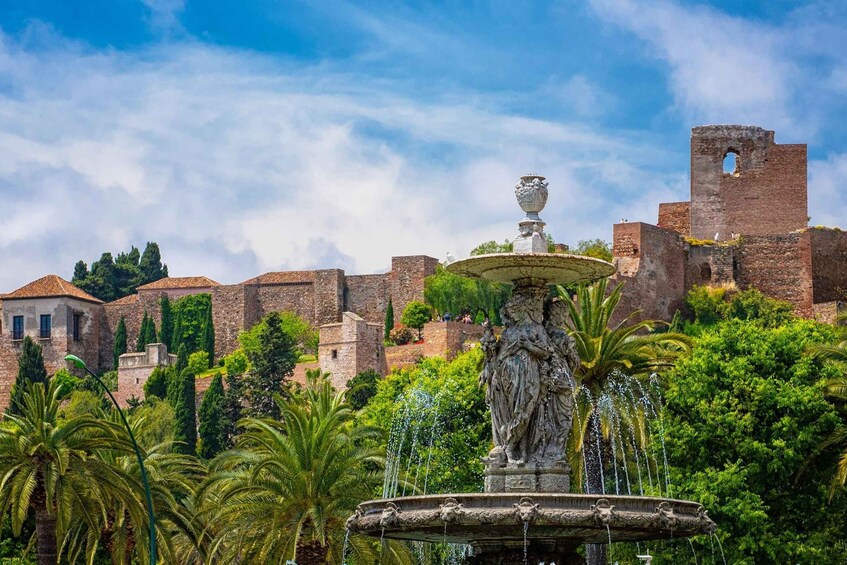 A historic fountain with a statue, surrounded by lush greenery and ancient stone walls. 4