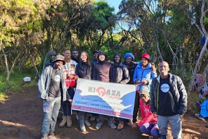 A group of people holding a banner for Kisoaza Tread Trips. 2