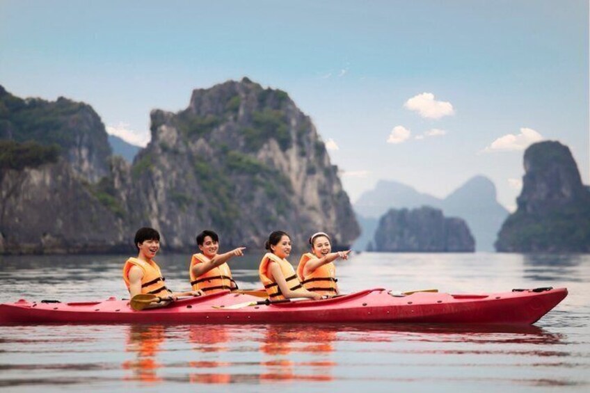 Una canoa roja con cuatro personas usando chalecos salvavidas en aguas tranquilas, con un paisaje montañoso al fondo. 3
