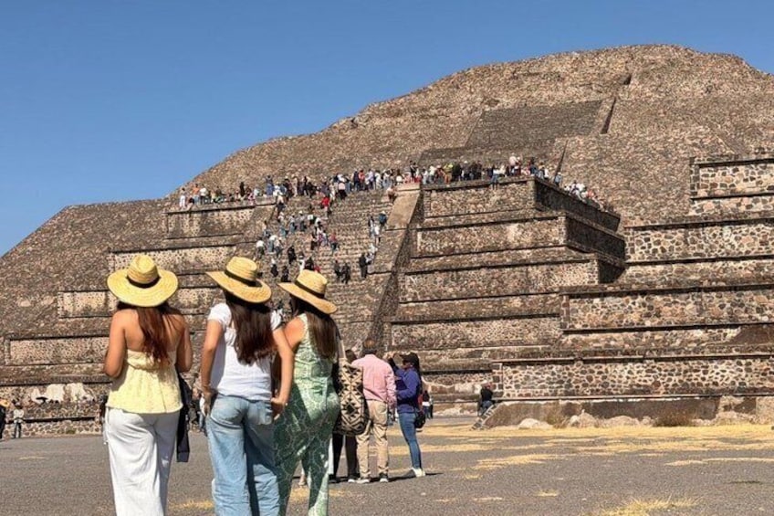 Una gran pirámide con gente subiendo por sus escalones. 1