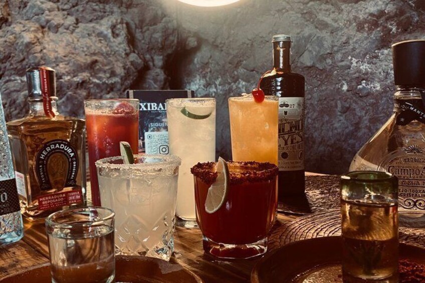 Variedad de botellas y vasos sobre una superficie de madera con un fondo texturizado. 5