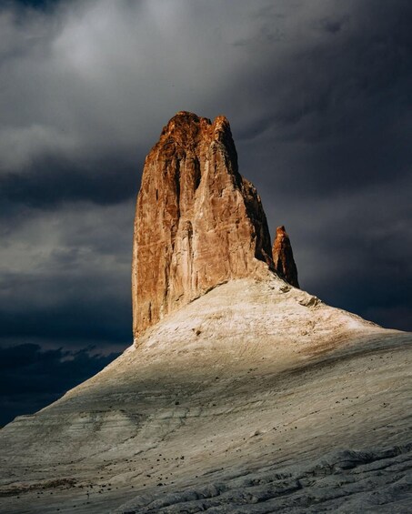 A rugged mountain peak with a distinct overhang and a snow-covered slope. 4