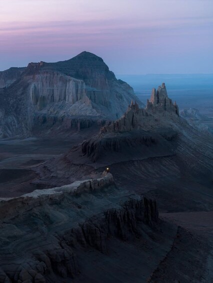 A rugged landscape with a prominent mountain and distinctive rock formations. 1