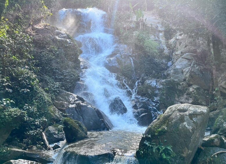A waterfall cascading over rocks in a forested area. 4