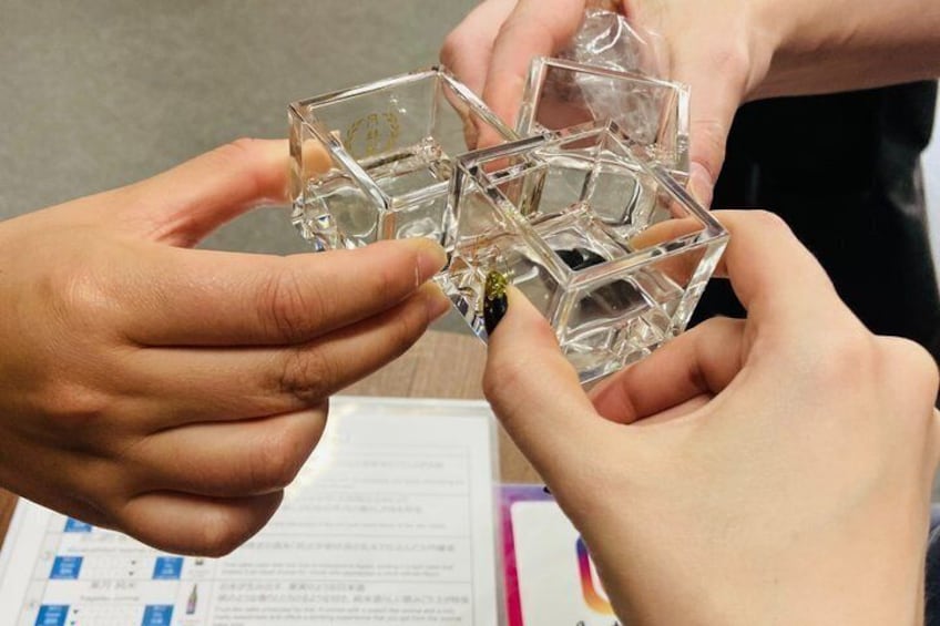 Hands holding a clear, geometric glass object. 1