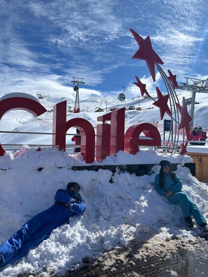 A snowy landscape with a large sign reading 'Chile' and a ski lift in the background. 5