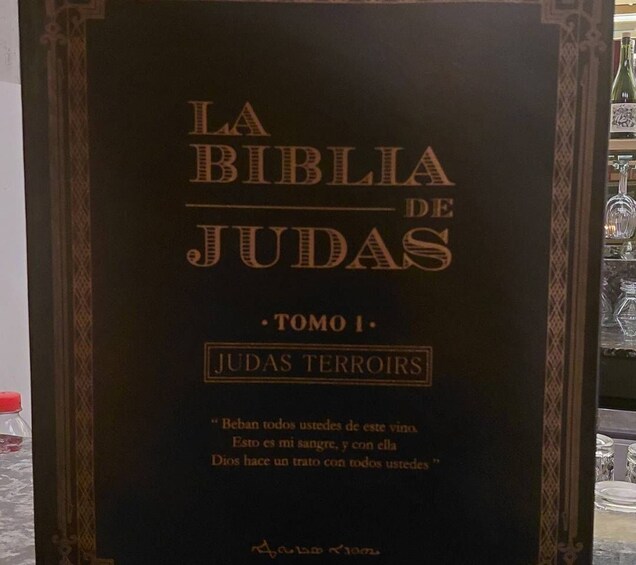 A book titled 'LA BIBLIA DE JUDAS TOMO I: JUDAS TERROIIRS' with a quote on the cover. 5