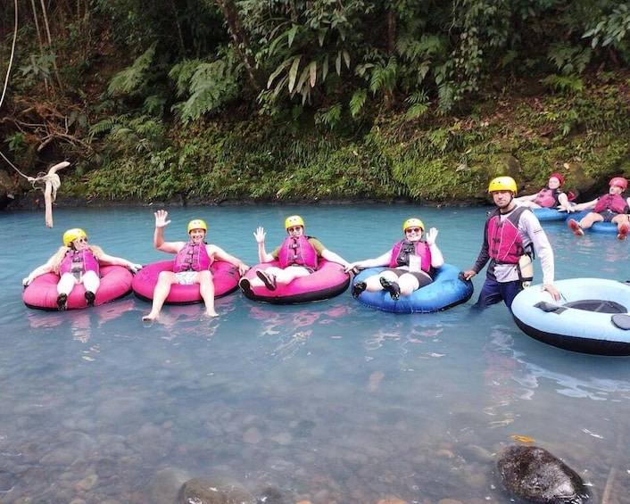People floating on tubes in a river surrounded by greenery. 2