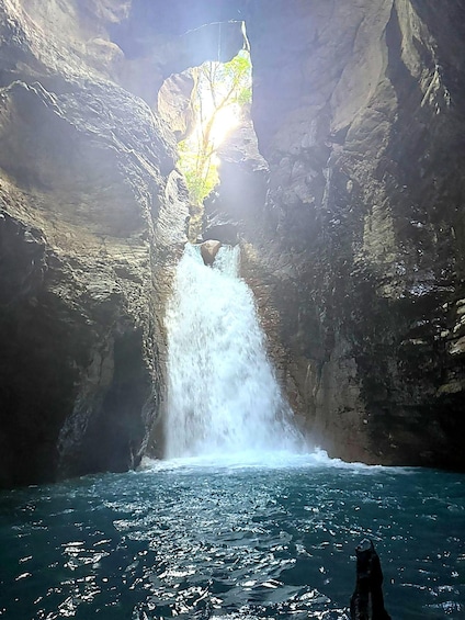 A waterfall cascading into a pool surrounded by rocky cliffs. 4
