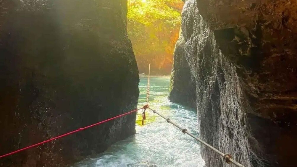 A river flowing through a canyon with a red rope bridge. 2