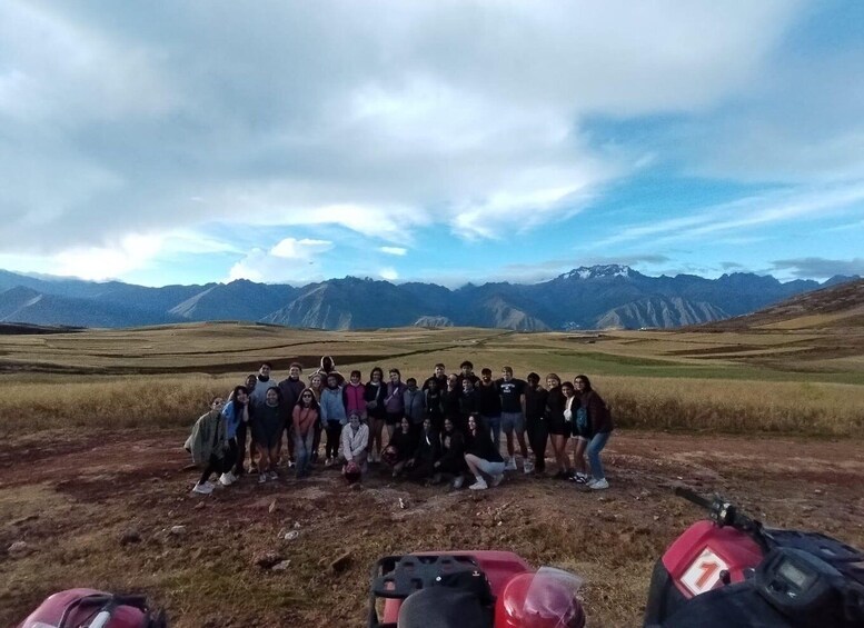 A group of people posing in a mountainous landscape with a clear sky. 5