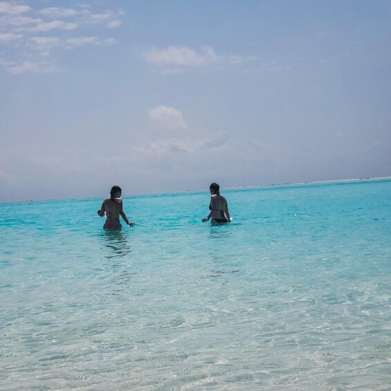 Two people wading in clear turquoise water. 5