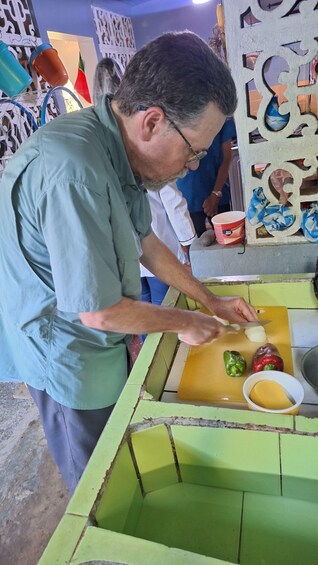 A person slicing a red pepper on a yellow cutting board. 4