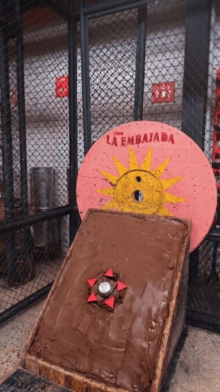 A pinball machine with a sun design and the text 'LA EMBAJADA' on the back. 2