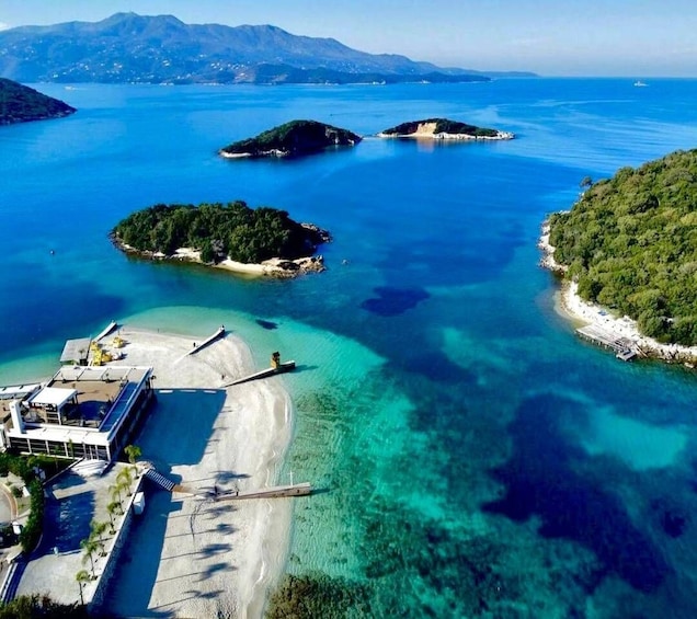 A coastal landscape with clear blue waters, a sandy beach, and several small islands. 5