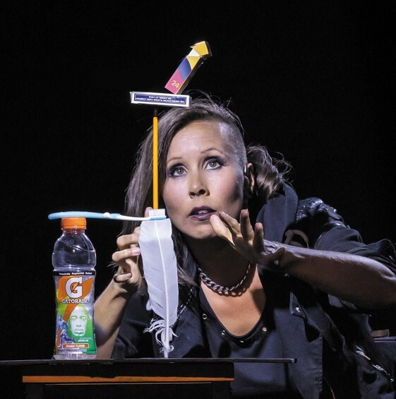 A person holding a Gatorade bottle and a feather. 5