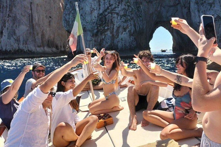 Un grupo de personas en un bote cerca de una costa rocosa bajo un cielo despejado. 5