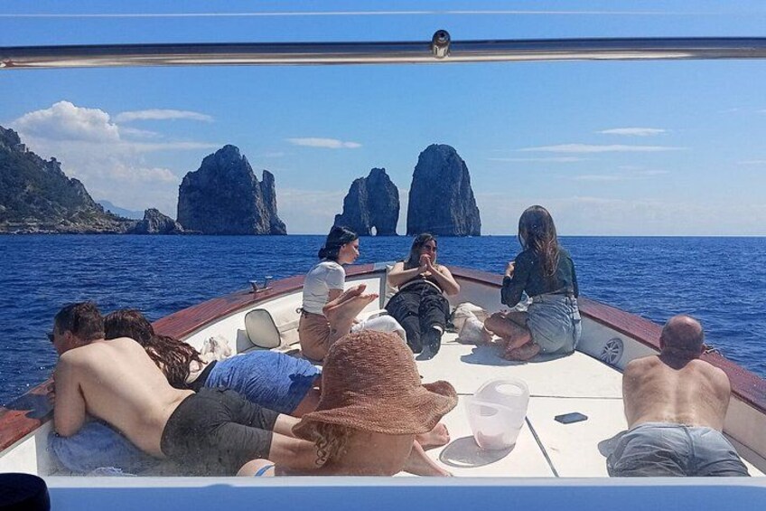 Un grupo de personas en un barco, con formaciones rocosas al fondo. 4