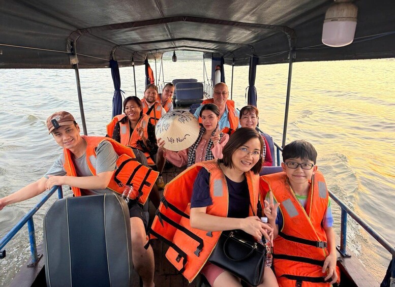 A group of people on a boat wearing life jackets. 1