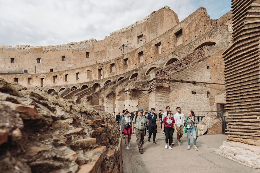 Ein antikes Amphitheater mit Ruinen und einer Gruppe von Touristen. 4