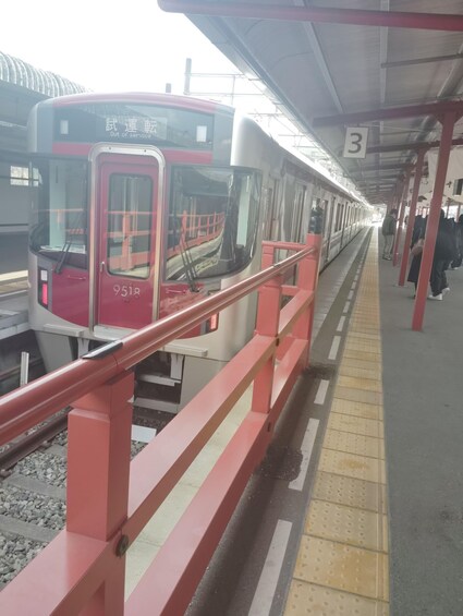 A train station platform with a red train marked '9518' and a platform number '3'. 3