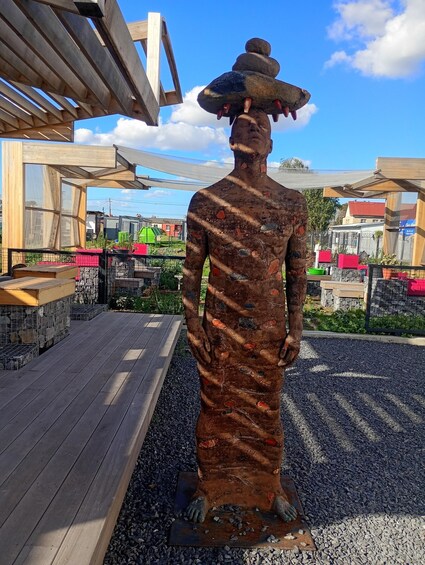 A statue of a person wearing a hat and holding a stone. 2