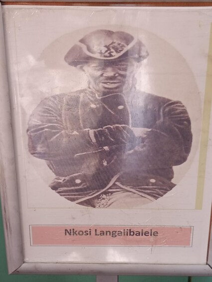 A historical photograph of a person in military attire with a caption 'Nkosi Langalibaiyele' below. 4