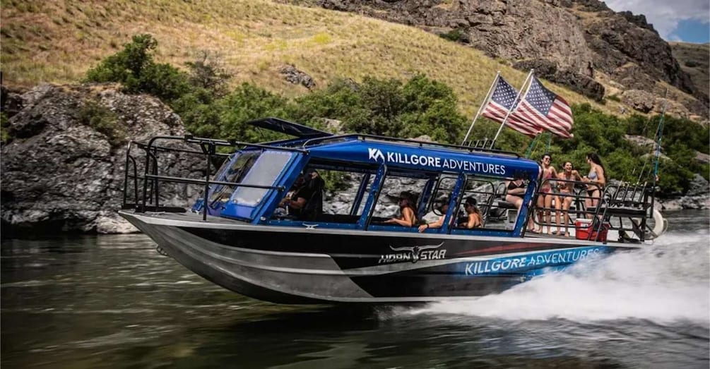 A boat named 'Killgore Adventures' on a river with passengers and an American flag. 4