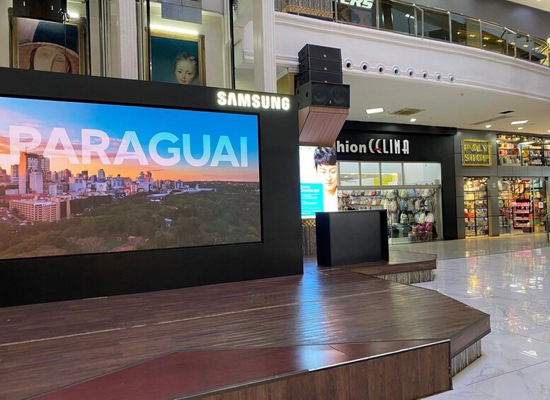 A Samsung display with a cityscape of Paraguay, a clothing store, and a Poly Shop. 5