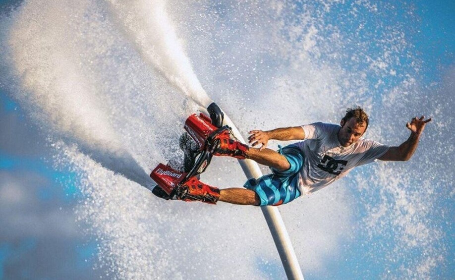 A person performing a trick on a jet ski, with water spraying around them. 2