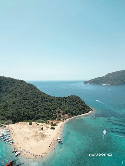 An aerial view of a coastal area with a beach, boats, and a clear blue sea. 2