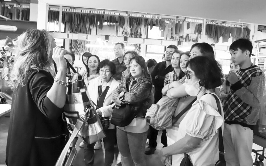 A group of people in a store with hanging items on the wall. 2
